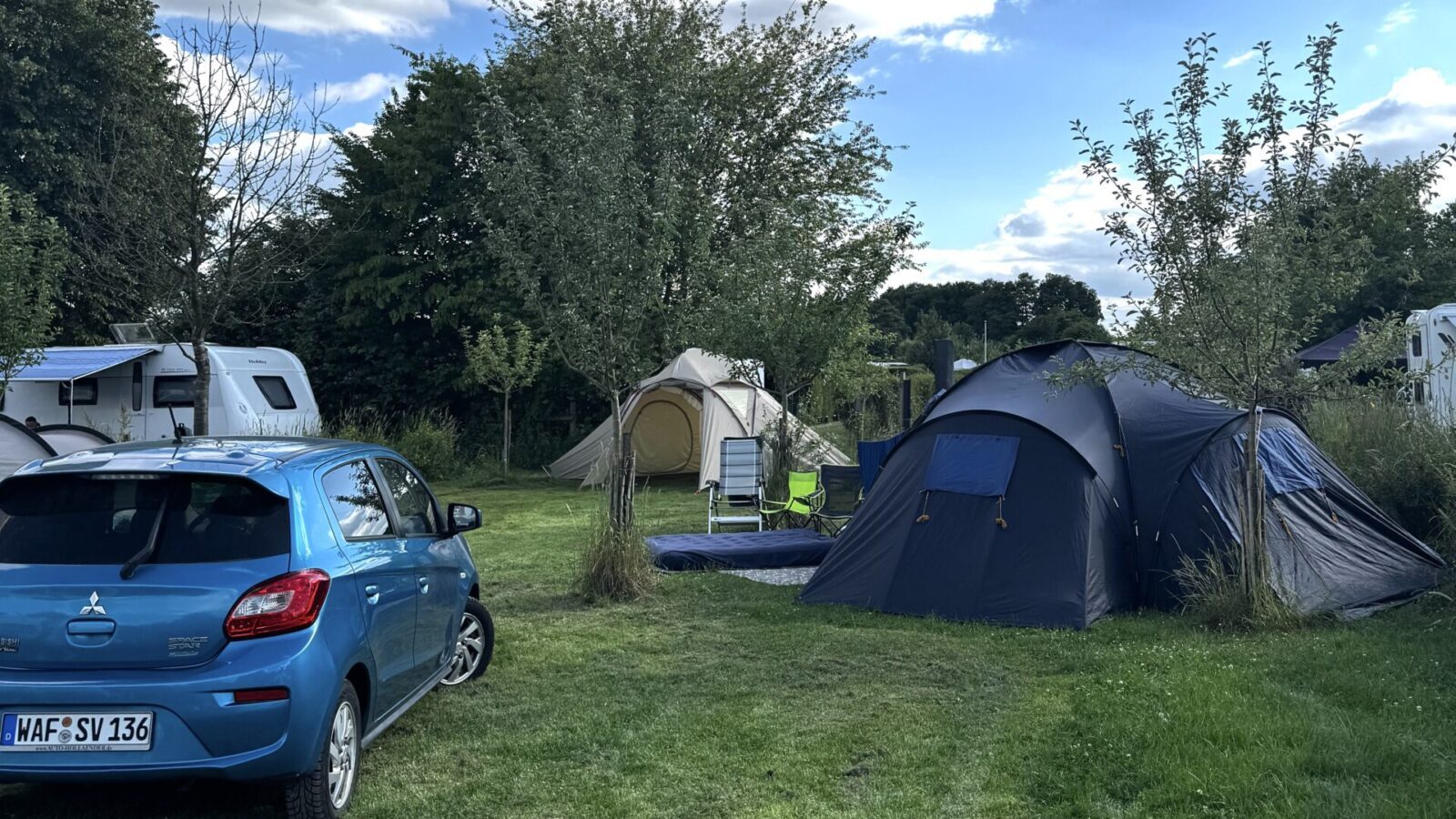 Autos, Caravans und Zelte auf einer Grünfläche